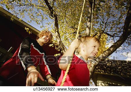 Pushing boy on swing View Large Photo Image Stock Photo - Pushing boy on swing. Fotosearch