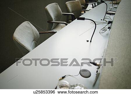 Stock Photograph - Row of chairs with table. Fotosearch