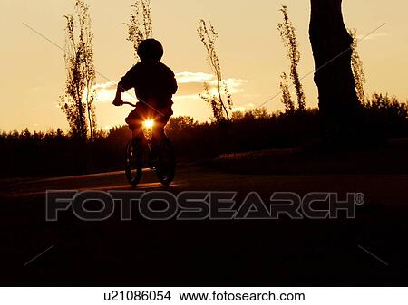 Silhouette of child riding a bike View Large Photo Image Picture - Silhouette of child riding a bike. Fotosearch