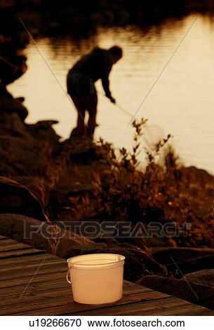 Silhouette of person netting fish View Large Photo Image Stock Image - Silhouette of person netting fish. Fotosearch