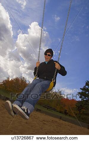 Teenager on a swing View Large Photo Image Stock Photo - Teenager on a swing. Fotosearch