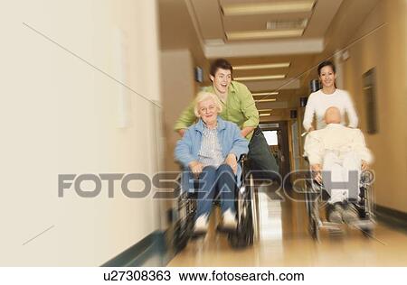 Stock Image - Two young people racing wheelchairs. Fotosearch