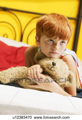 Stock Image - Young super hero holding teddy bear. Fotosearch