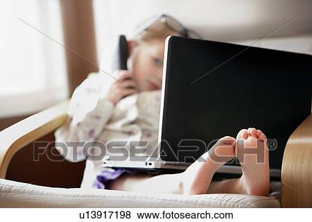 Child working on phone and computer View Large Photo Image Stock Photo - Child working on phone and computer. Fotosearch