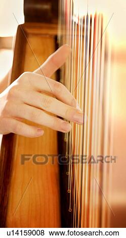 Fingers plucking on strings of a harp View Large Photo Image Stock Photo - Fingers plucking on strings of a harp. Fotosearch
