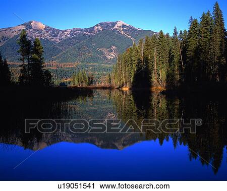 Stock Image - Holland Lake, Swan Range mountains, reflected autumn colors, Swan Valley. Fotosearch