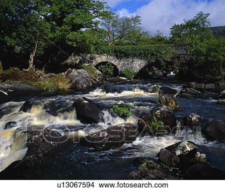 Picture - Old stone bridge and rushing stream, Killarney National Park. Fotosearch