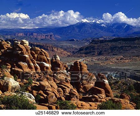 Stock Photo - Redrock formations called the Fiery Furnace, La Sal Mountains in distance, Arches National Park. Fotosearch