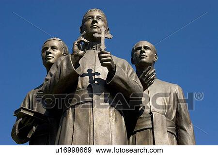 Statue of men holding cross and book View Large Photo Image Stock Photo - Statue of men holding cross and book. Fotosearch