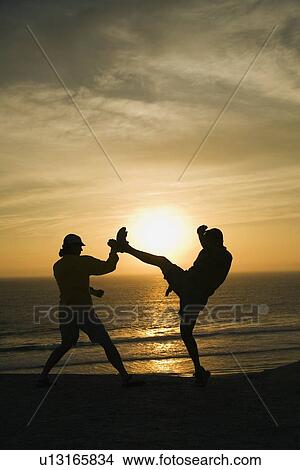 Two men fighting on a beach View Large Photo Image Picture - Two men fighting on a beach. Fotosearch