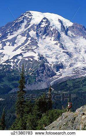 Stock Image - View of Mount Rainier with backpacker, Mount Rainier National Park. Fotosearch