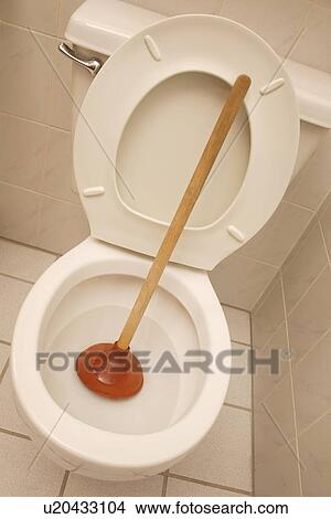 Picture - A toilet with a plunger. Fotosearch