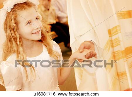 Child holds priest's hand during first communion View Large Photo Image Stock Photograph - Child holds priest's hand during first communion. Fotosearch