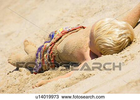 Child lays on the sand View Large Photo Image Stock Image - Child lays on the sand. Fotosearch