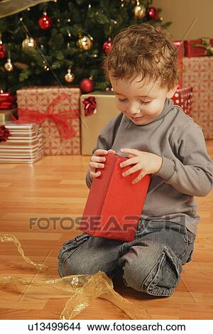 Child opens Christmas present View Large Photo Image Picture - Child opens Christmas present. Fotosearch