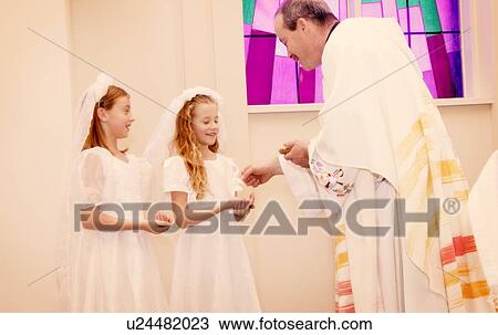 Stock Image - Children take their first communion. Fotosearch