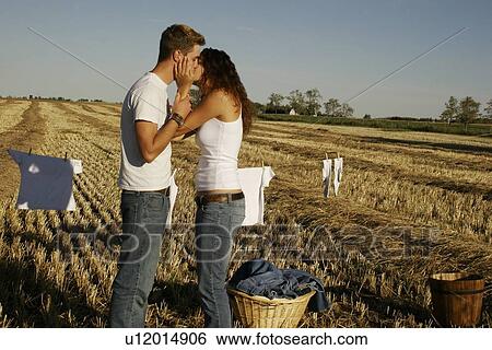 Couple hanging up laundry View Large Photo Image Stock Photograph - Couple hanging up laundry. Fotosearch