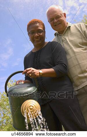 Picture - Couple with watering can. Fotosearch