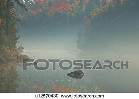 Stock Image - Fog over scenic water. Fotosearch