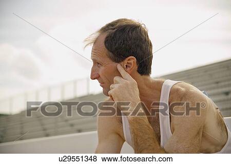 Male athlete sitting in stands View Large Photo Image Stock Photo - Male athlete sitting in stands. Fotosearch