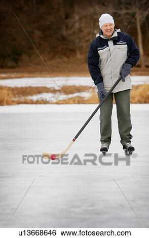 Man playing shinny hockey View Large Photo Image Stock Photograph - Man playing shinny hockey. Fotosearch