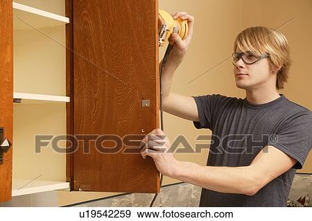 Man sanding kitchen cabinets View Large Photo Image Stock Photo - Man sanding kitchen cabinets. Fotosearch