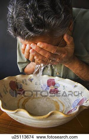 Picture - Man washes his face. Fotosearch
