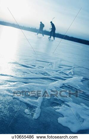 Stock Photograph - Playing hockey on a frozen lake. Fotosearch