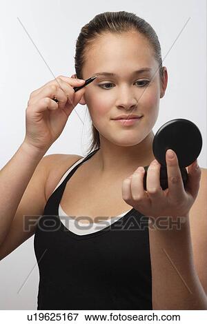 Stock Photo - Teenager with compact mirror. Fotosearch
