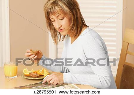 Stock Image - Woman eating breakfast. Fotosearch