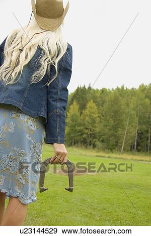 Stock Photo - Woman throws horseshoe. Fotosearch