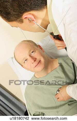 A doctor examines a patient using a stethoscope View Large Photo Image Stock Image - A doctor examines a patient using a stethoscope. Fotosearch