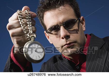 A man holding up a pocket watch View Large Photo Image Stock Photograph - A man holding up a pocket watch. Fotosearch