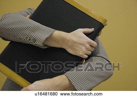 Stock Image - Arms wrapped around a book. Fotosearch