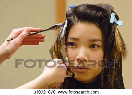 Stock Image - Closeup of woman getting hair foils. Fotosearch