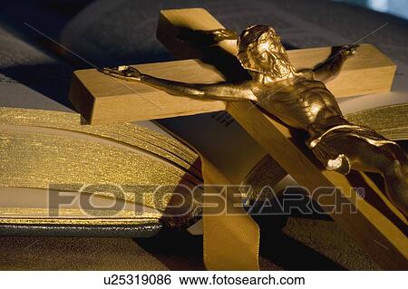 Crucifix laying on open Bible View Large Photo Image Stock Photograph - Crucifix laying on open Bible. Fotosearch