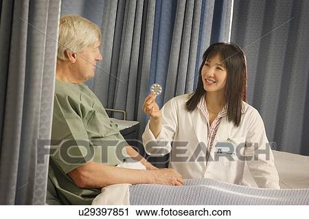 Stock Image - Doctor prescribes pills to patient. Fotosearch