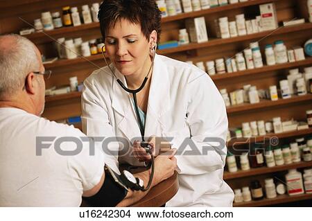 Picture - Doctor takes an older patients' blood pressure. Fotosearch