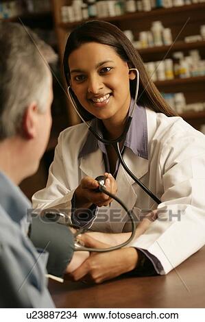 Doctor taking patient's blood pressure View Large Photo Image Picture - Doctor taking patient's blood pressure. Fotosearch