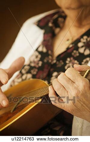 Elderly woman playing a mandolin View Large Photo Image Stock Image - Elderly woman playing a mandolin. Fotosearch