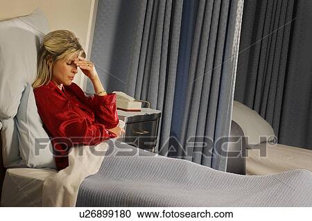 Stock Image - Female patient with hand over her face. Fotosearch