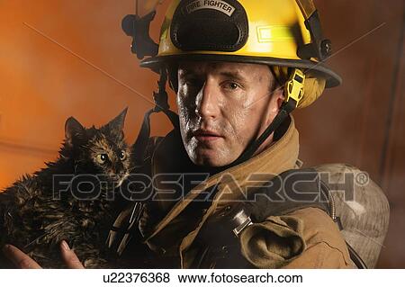 Firefighter and a cat View Large Photo Image Stock Photo - Firefighter and a cat. Fotosearch