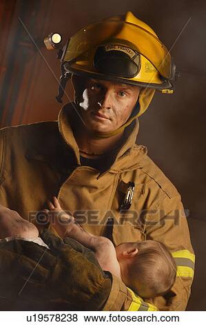 Fireman holding a baby View Large Photo Image Stock Photo - Fireman holding a baby. Fotosearch