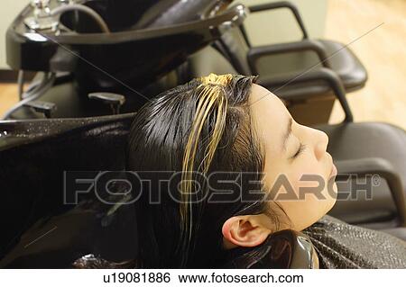 Stock Photograph - Getting hair washed at the hair salon. Fotosearch