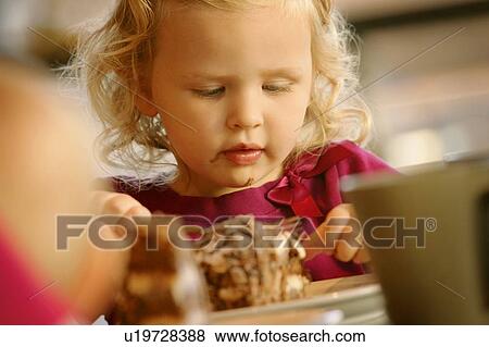 Stock Photo - Girl eating dessert. Fotosearch