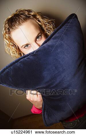 Girl hiding behind a pillow View Large Photo Image Stock Image - Girl hiding behind a pillow. Fotosearch