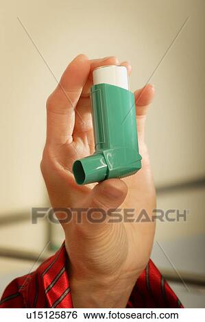 Stock Photograph - Hand holding an inhaler. Fotosearch