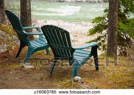 Lawn chairs situated by the water View Large Photo Image Stock Photography - Lawn chairs situated by the water. Fotosearch