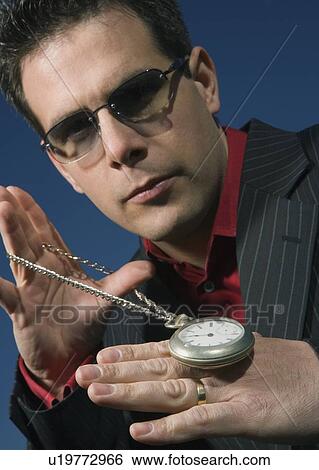 Man holding a pocket watch View Large Photo Image Stock Photograph - Man holding a pocket watch. Fotosearch