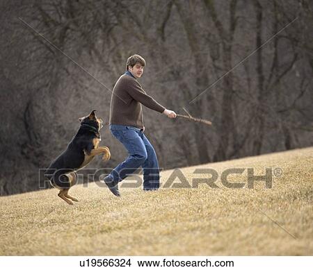 Man playing with dog View Large Photo Image Picture - Man playing with dog. Fotosearch